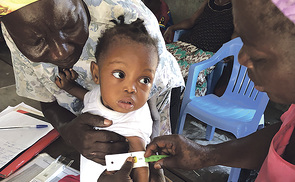 Die Caritas versorgt unterernährte Kinder im Kongo. Bevor das Kind den nahrhaften Brei bekommt, wird durch eine Untersuchung der Grad der Unterernährung festgestellt.